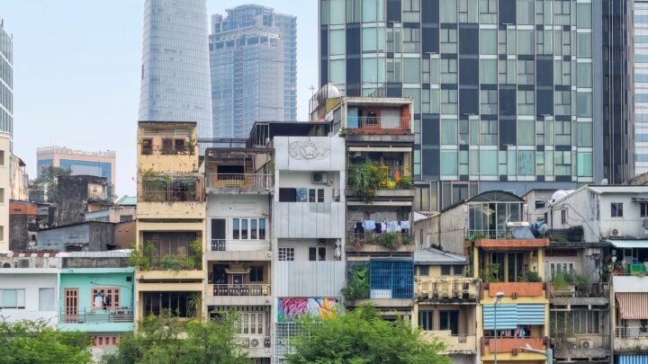 Contraste entre casas tradicionales vietnamitas y rascacielos modernos en Ho Chi Minh