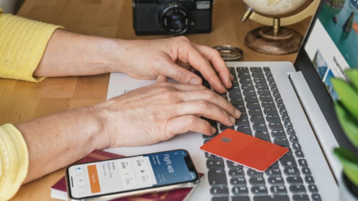 Persona reservando un viaje a Vietnam con tarjeta desde el portátil, comparando opciones online