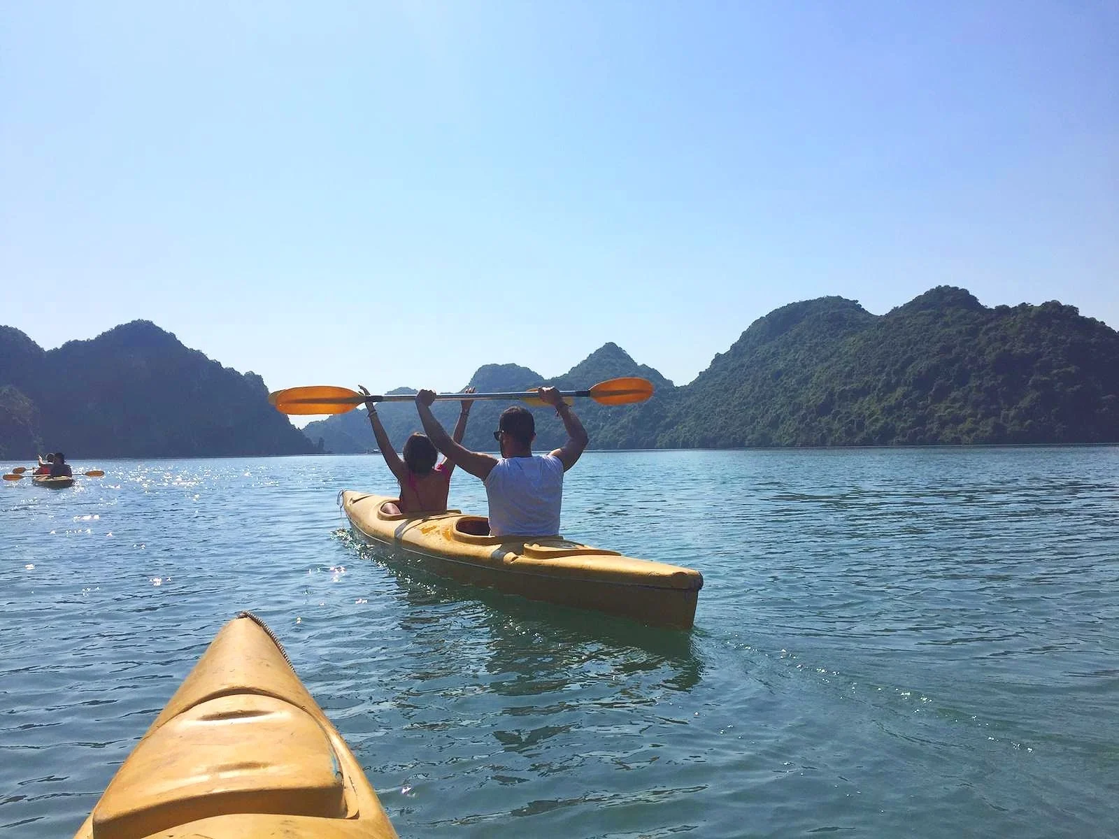 Dos viajeros disfrutando de una excursión en kayak por la Bahía de Halong.