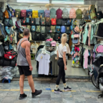 Tienda de mochilas y ropa The North Face en el Barrio Viejo de Hanoi con turistas mirando los productos