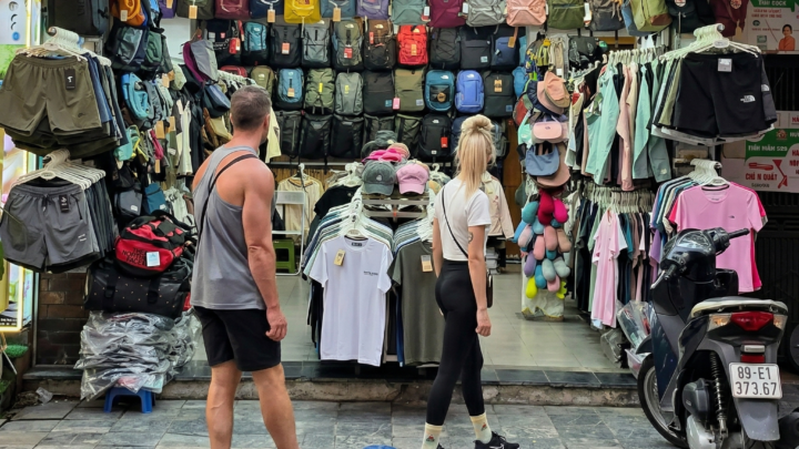 Tienda de mochilas y ropa The North Face en el Barrio Viejo de Hanoi con turistas mirando los productos