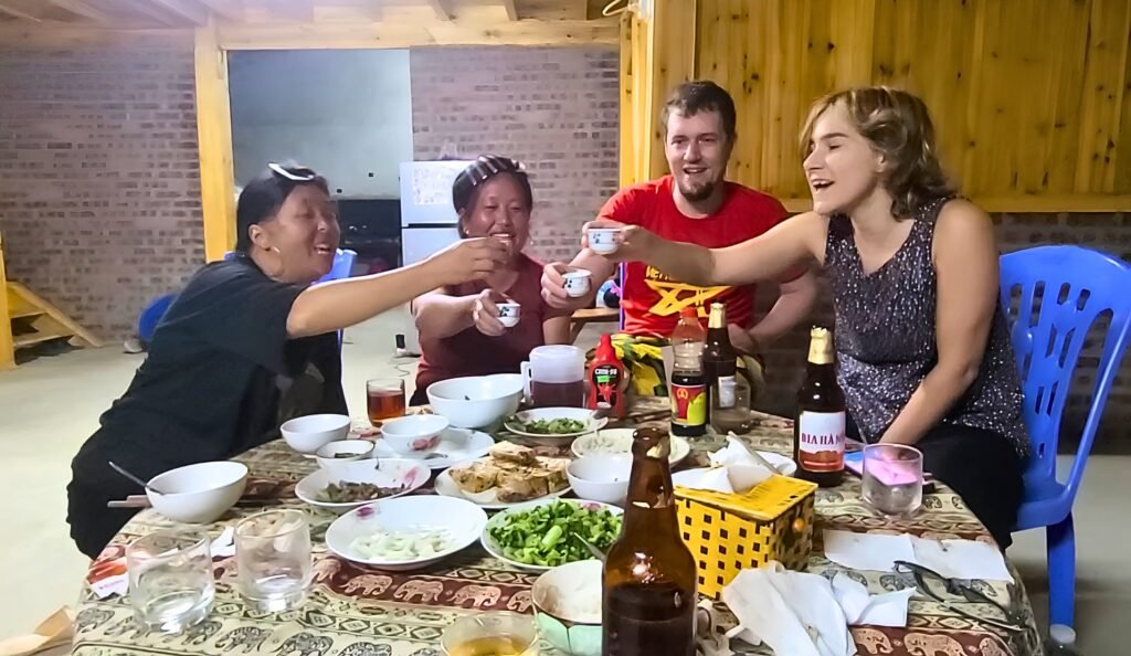 Alberto y otros viajeros brindando con licor de arroz durante la cena en casa de Mama Vu Vi, Sapa