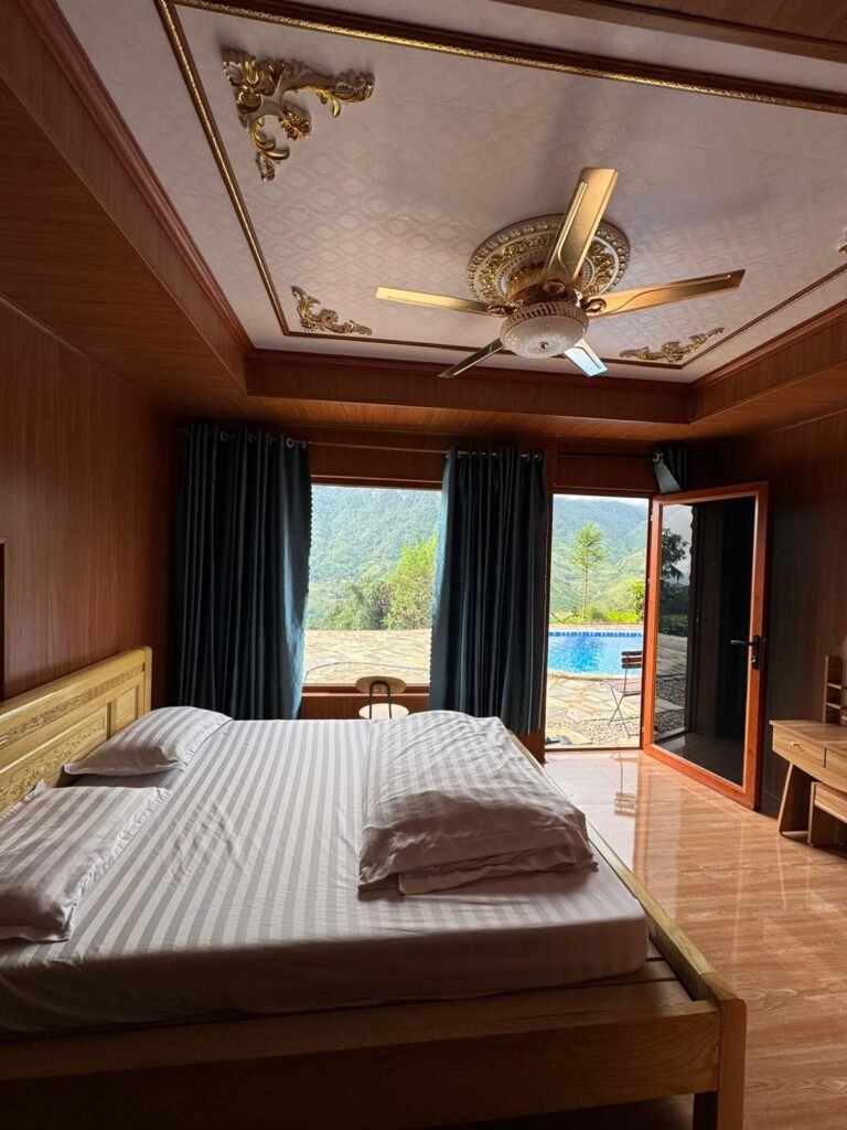 Habitación privada con cama doble y ventanal con vistas a la piscina en el alojamiento de Mama Mao, Sapa