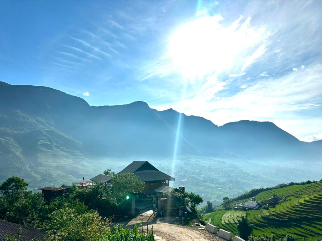 Casa rodeada de arrozales en terrazas con las montañas del valle de Sapa al fondo
