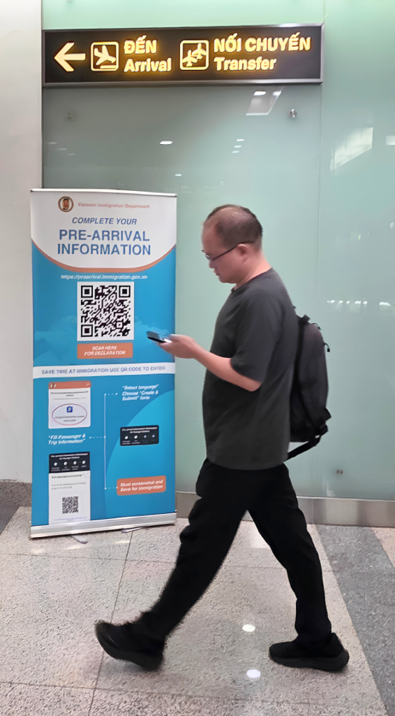 Cartel con QR de la declaración de entrada junto al pasillo de llegadas del aeropuerto de Hanoi.