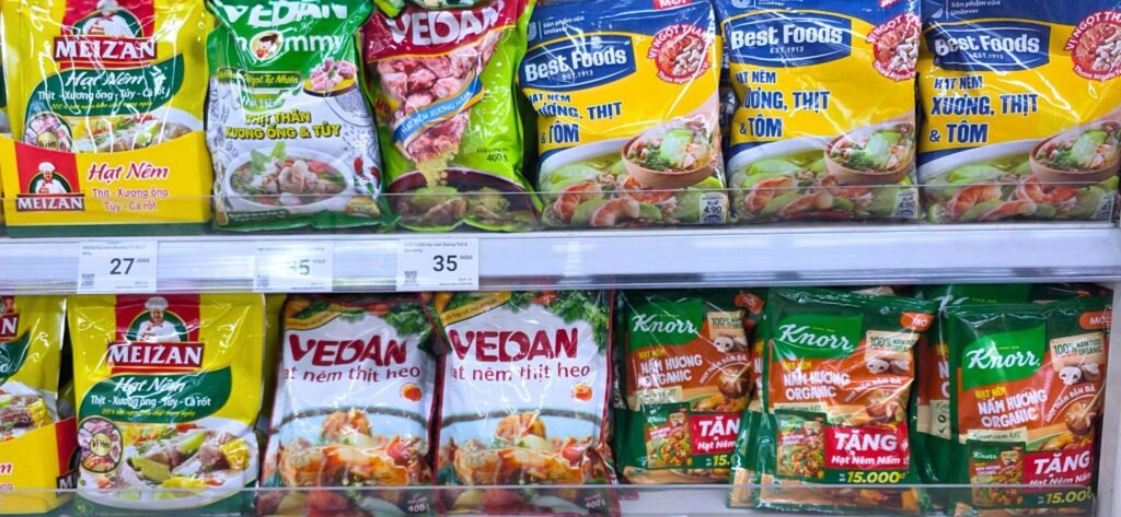 Variedad de caldos concentrados y sazonadores en polvo (Knorr, Vedan, Meizan) en un supermercado de Vietnam
