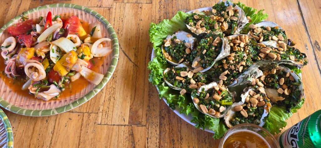 Plato de ostras con cacahuete y salteado de calamar con verduras servidos durante el tour del Hai Van Pass