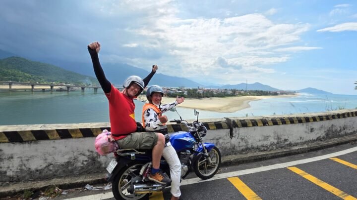 Alberto y un conductor local en una moto en el Hai Van Pass con la bahía de Lang Co al fondo